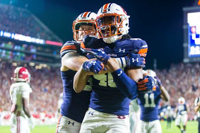 Auburn tight end Luke Deal (86) hugs Auburn tight end Landen King (40) as King celebrates a one-handed touchdown reception against Alabama during the first overtime of an NCAA college football game, Saturday, Nov. 27, 2021, in Auburn, Ala. The touchdown sent the game to a second overtime, a game won in four overtimes by Alabama, 24-22. (AP Photo/Vasha Hunt)